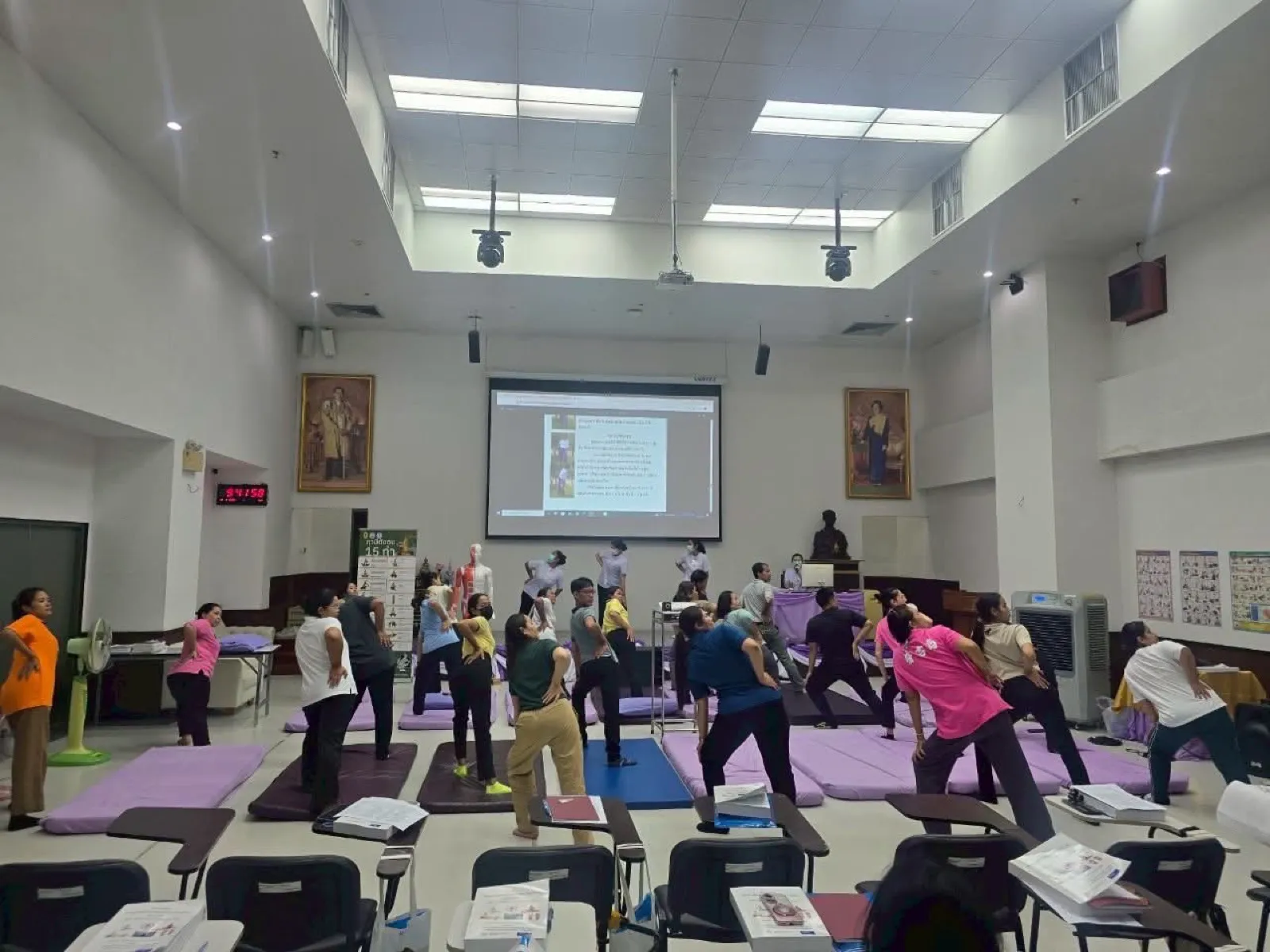 A class practising Thai therapeutic stretching together