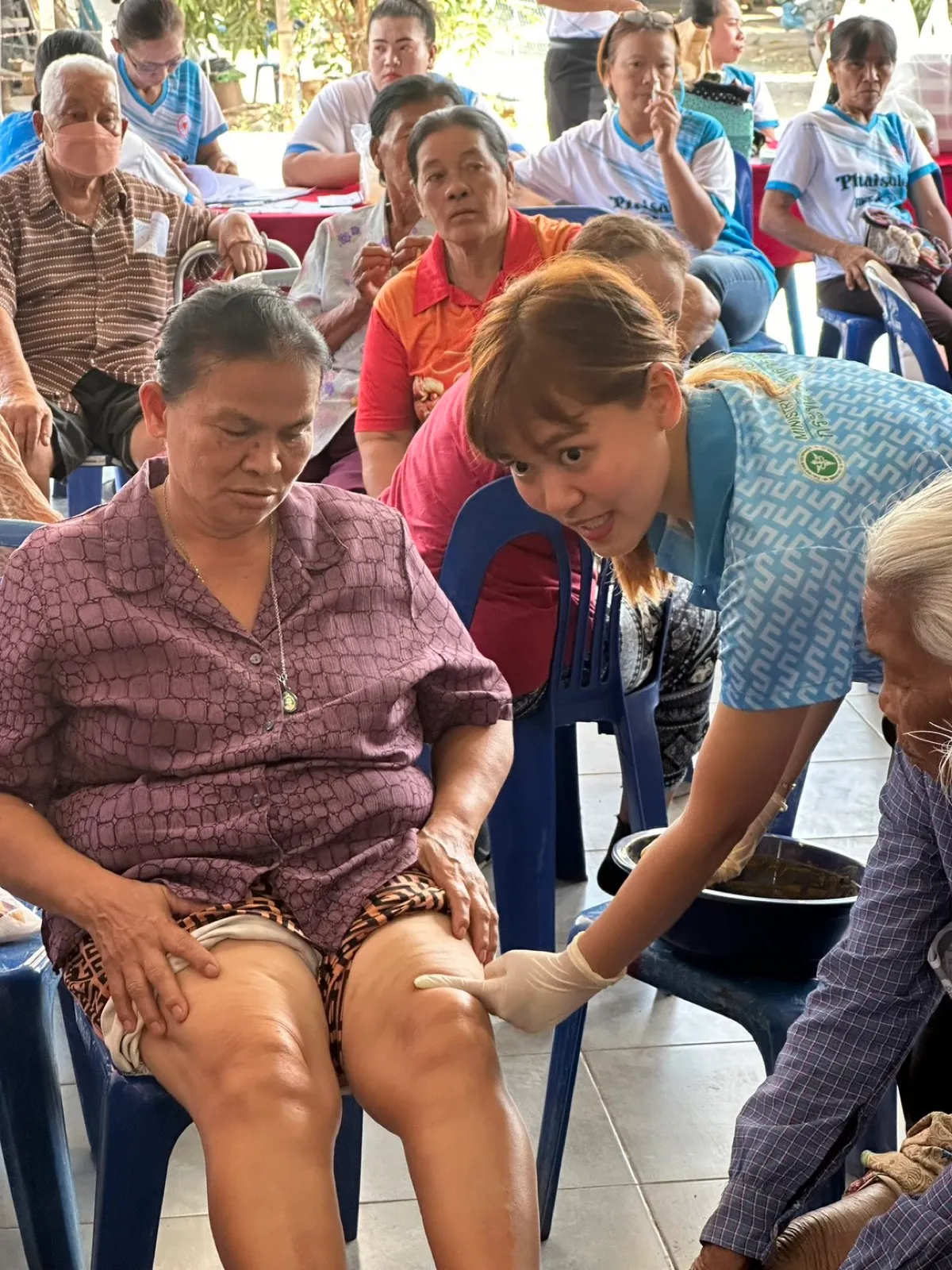 Examining an older patient’s knee during a community visit