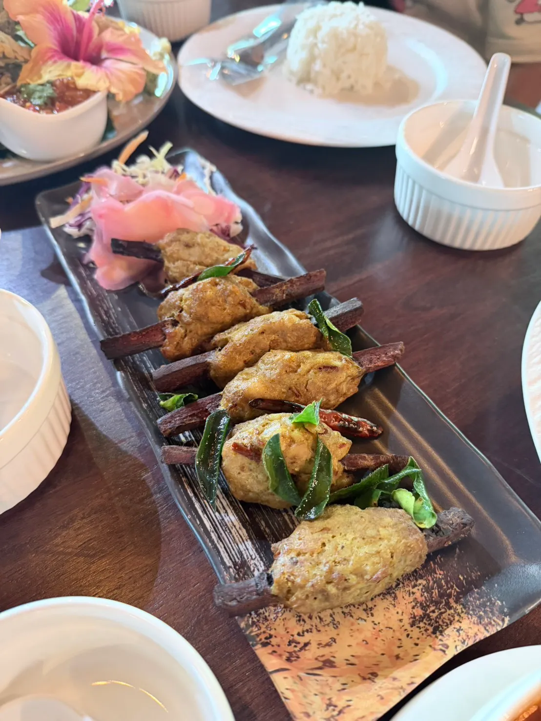 Fish cakes skewered on cinnamon bark